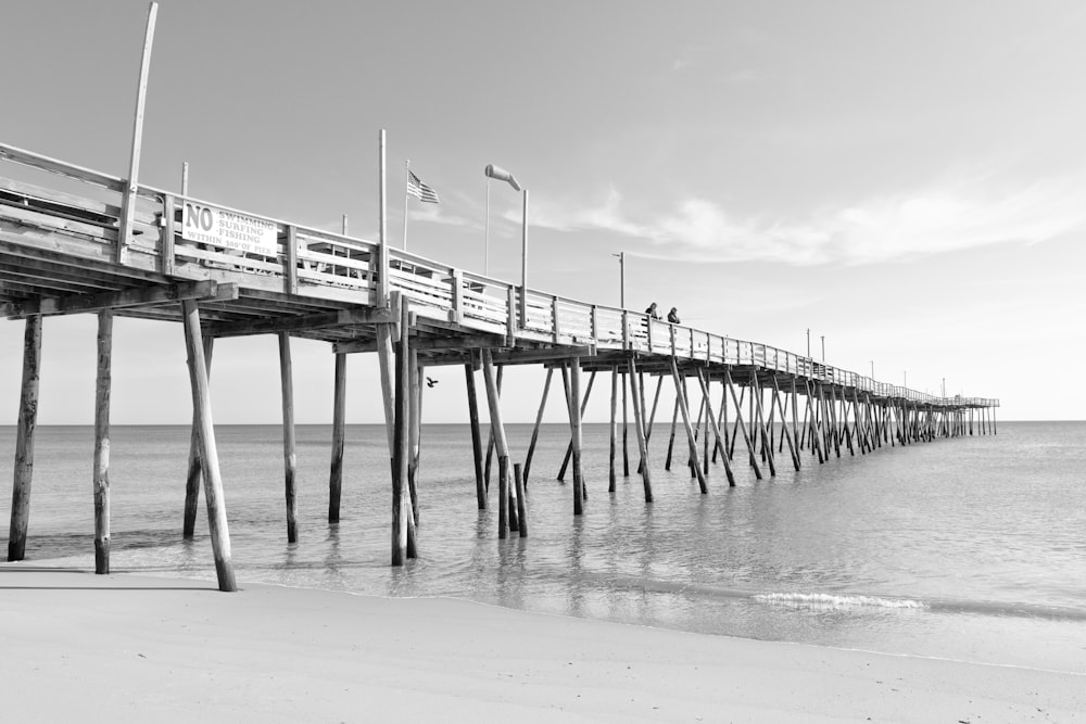 grayscale photo of wooden dock on sea