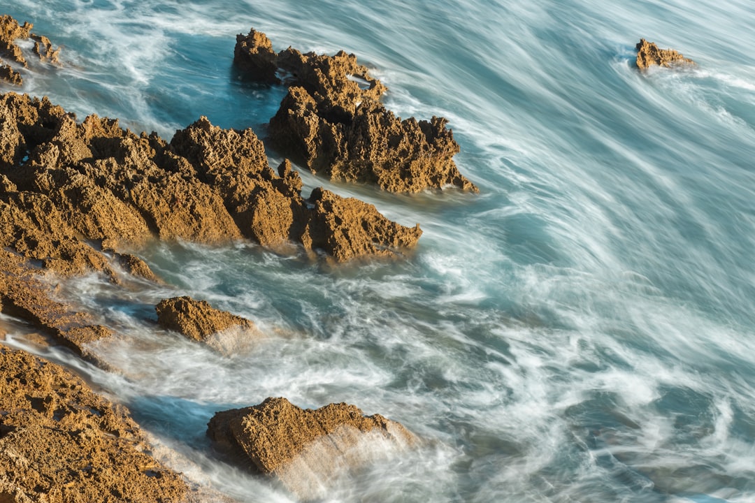 brown rock formation on sea during daytime