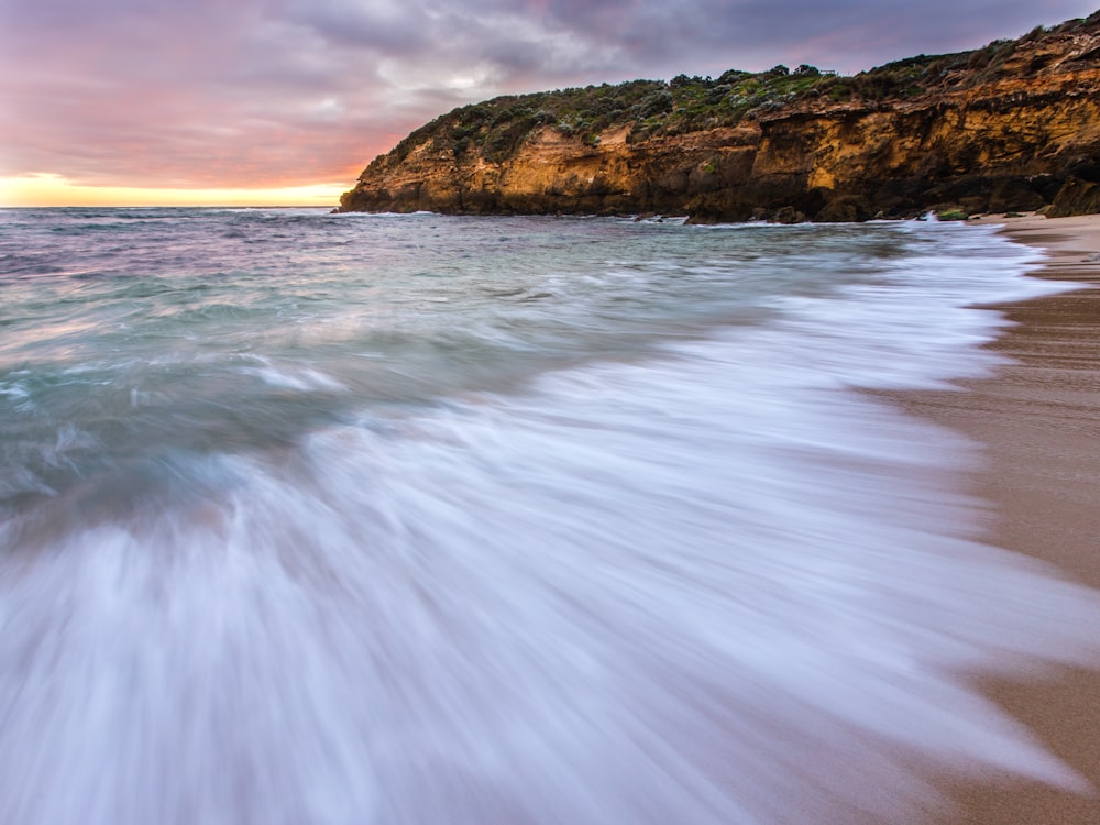 brown rock formation on sea water during daytime