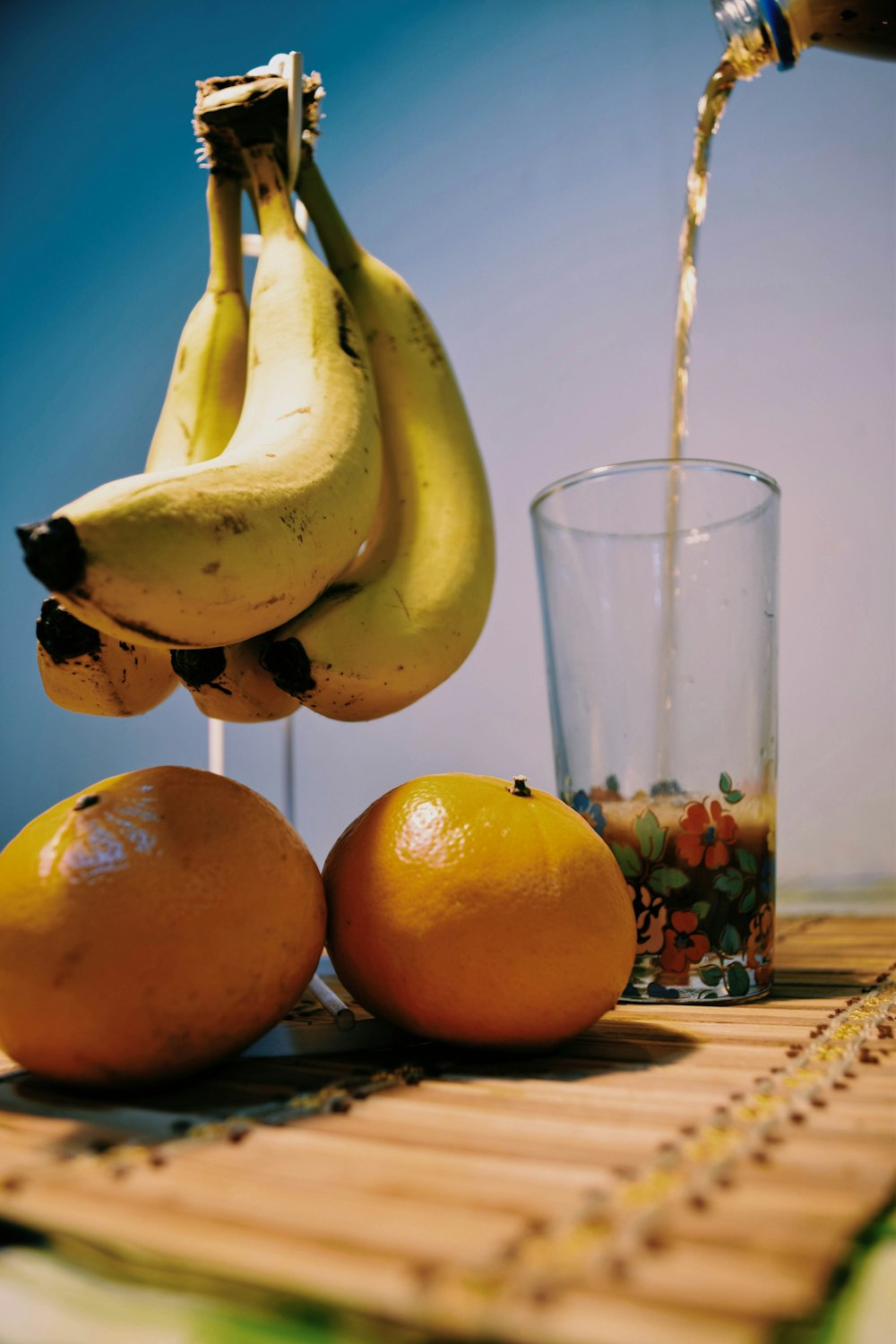 fruta de plátano amarillo al lado de un vaso transparente