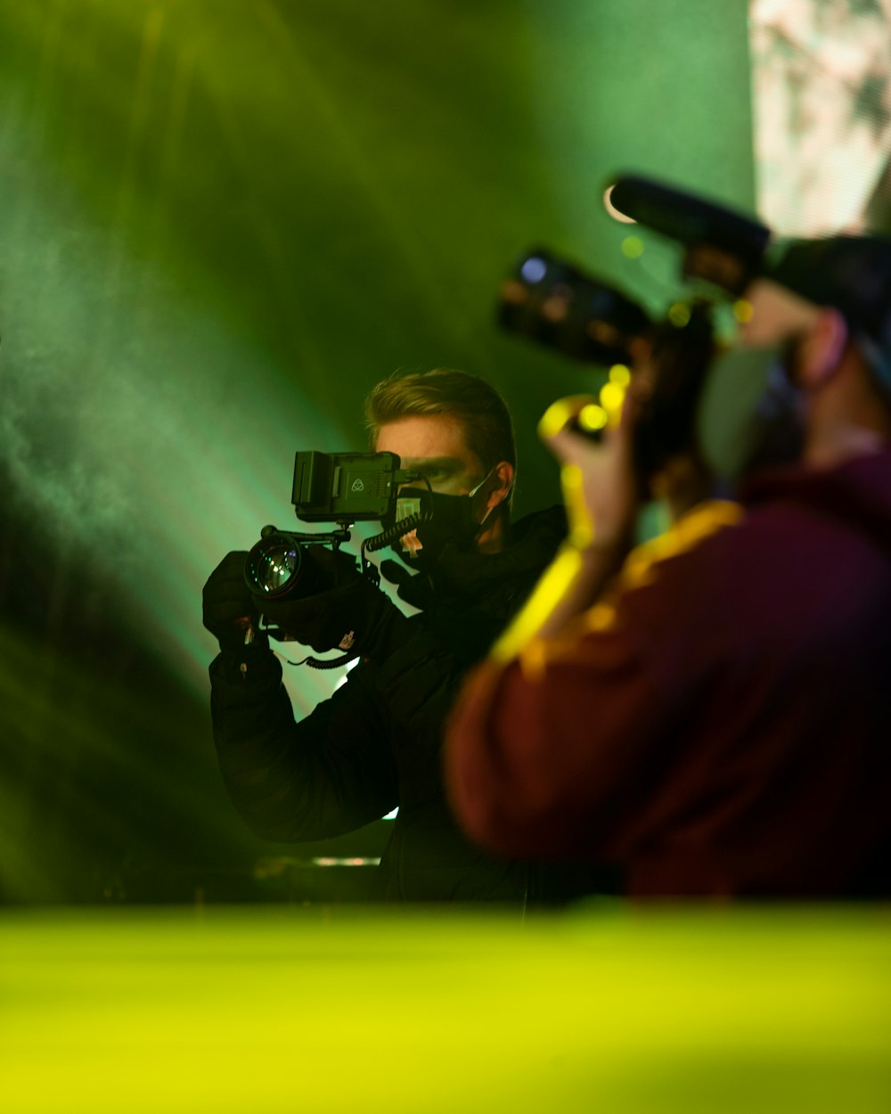 man in black jacket holding black dslr camera