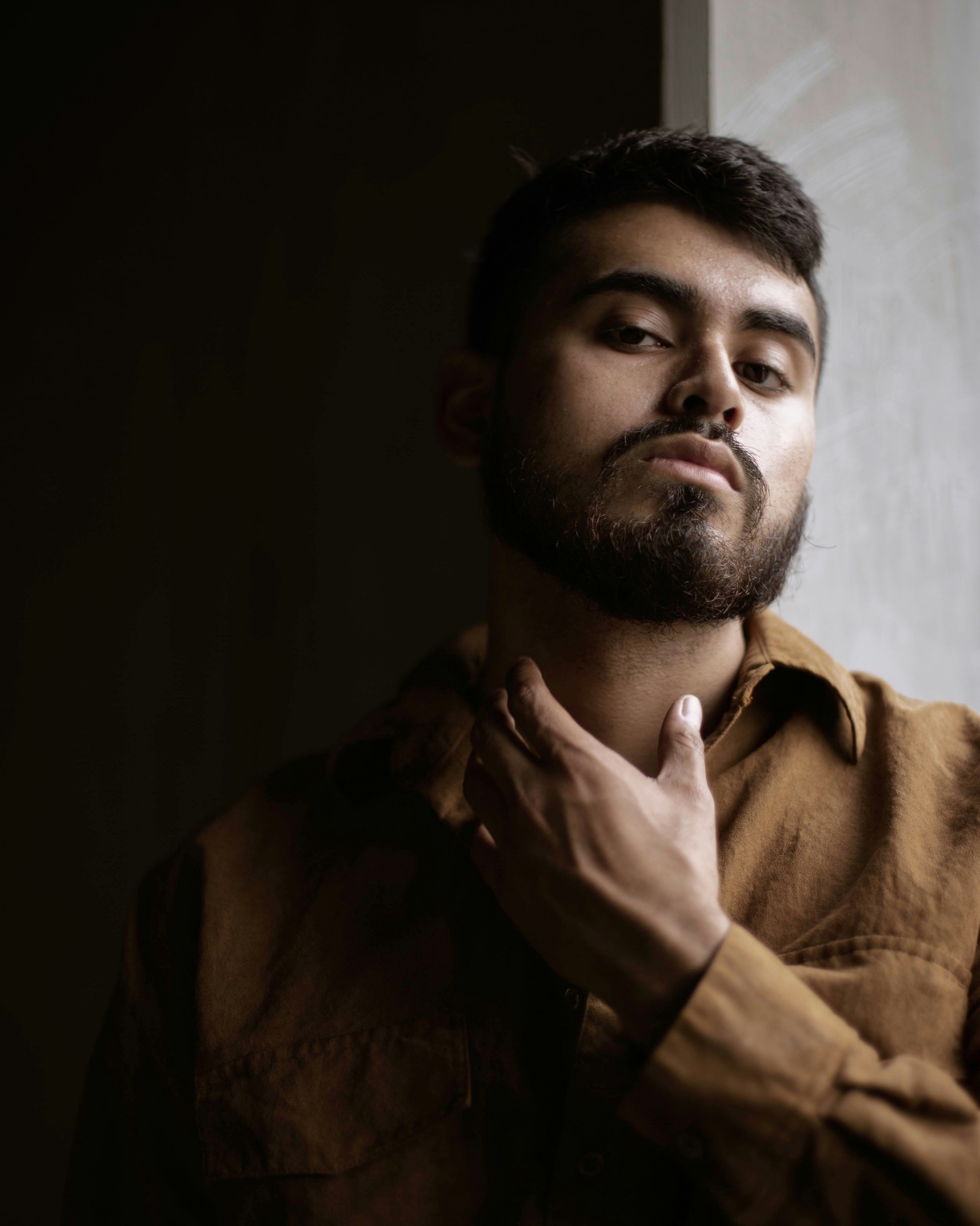 Man in brown jacket holding his face photo Free Black Image on Unsplash