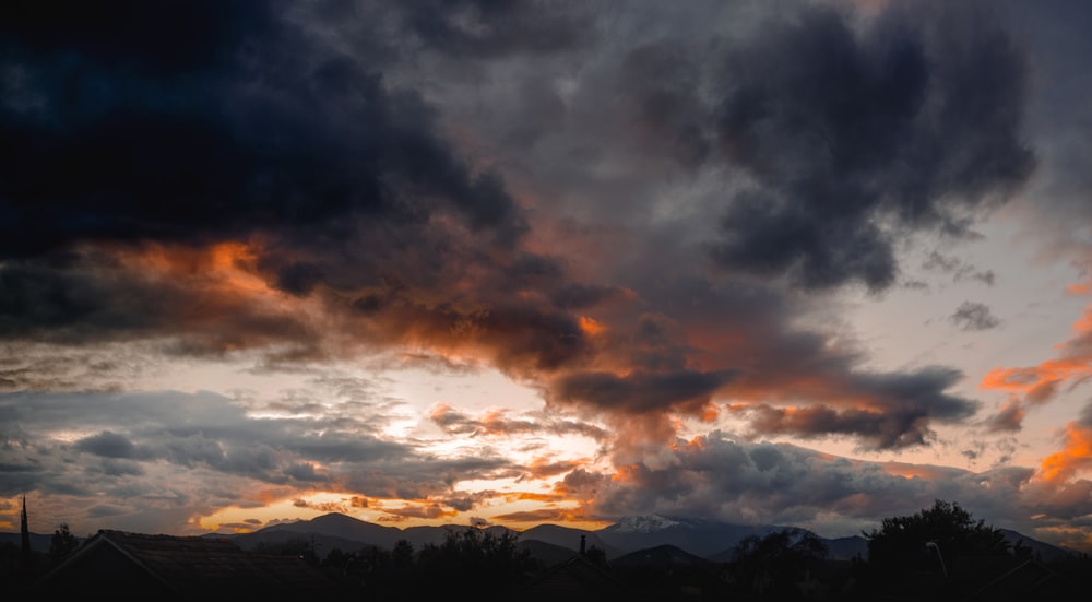 silueta de montañas bajo cielo nublado durante la puesta del sol