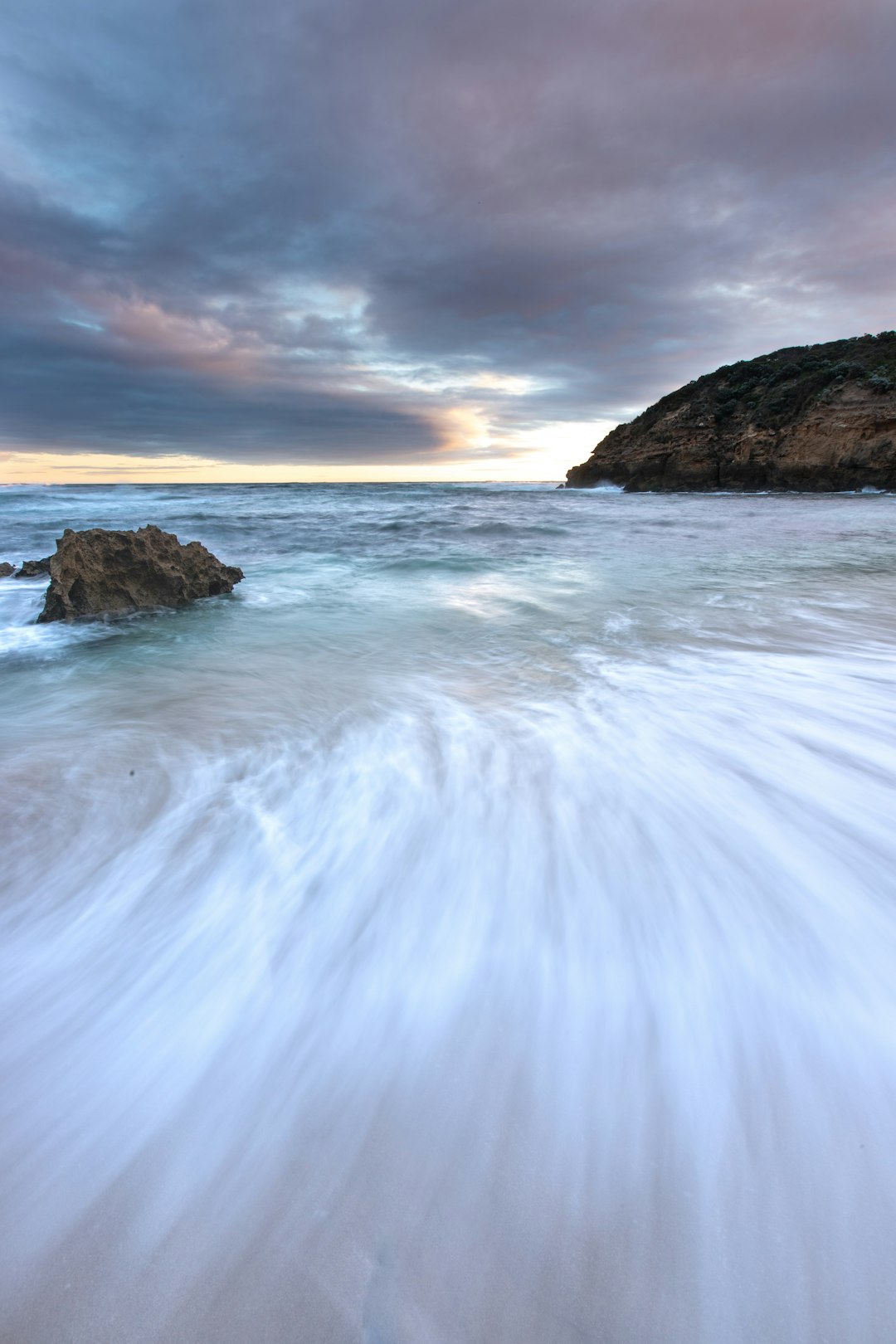 brown rock formation on sea water during daytime