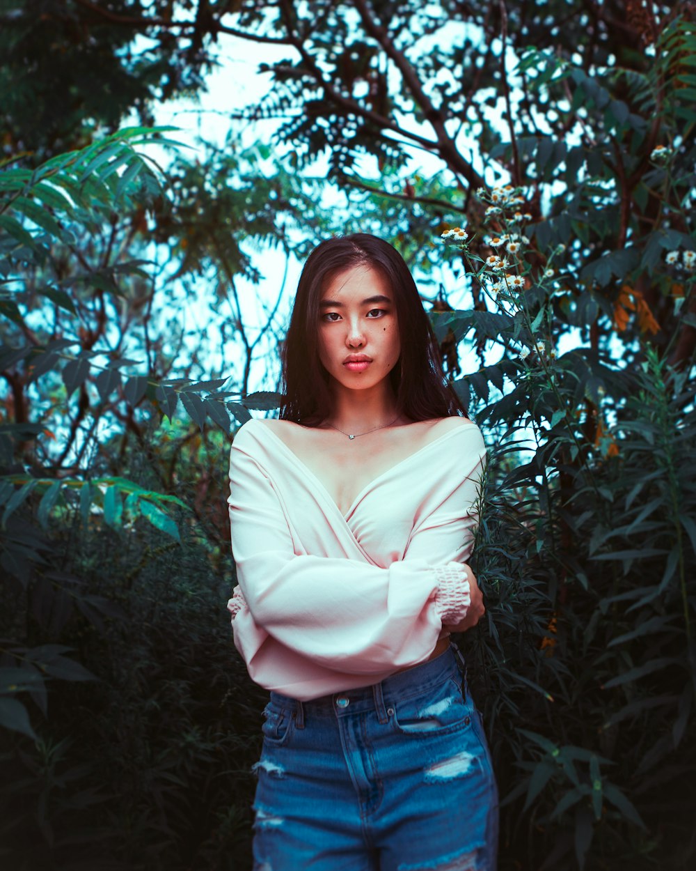 woman in white long sleeve shirt standing near green leaf tree