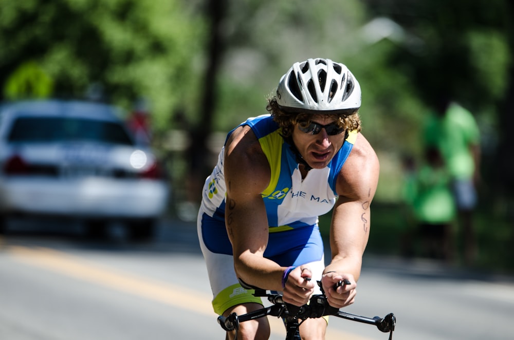 man in blue tank top riding on bicycle during daytime