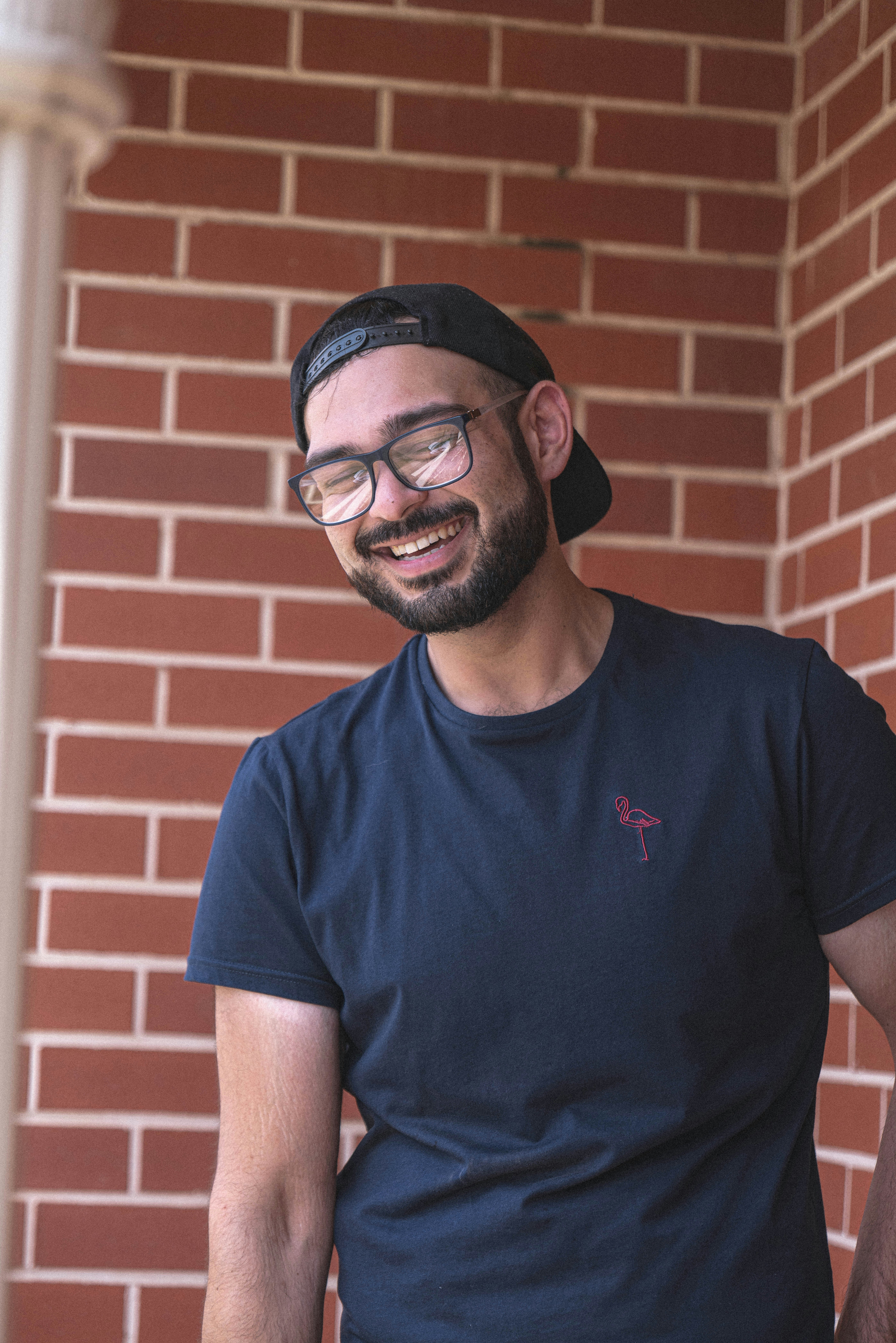 man in blue crew neck t-shirt wearing black framed eyeglasses