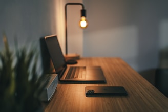 black laptop computer on brown wooden table