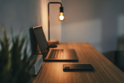 black laptop computer on brown wooden table desk zoom background