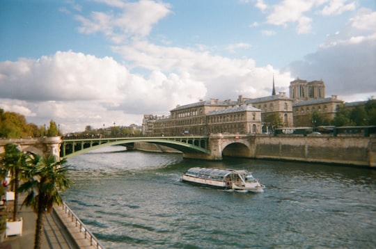 white boat on river near bridge during daytime in Sainte-Chapelle France