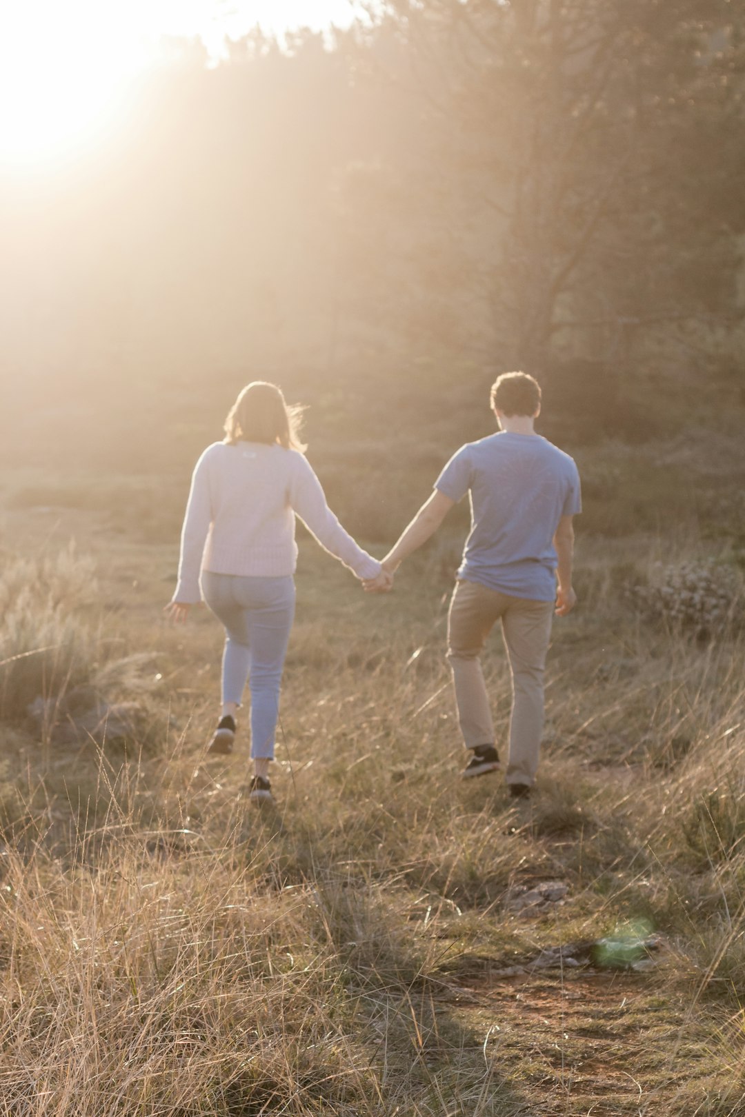 2 children walking on brown grass field during daytime