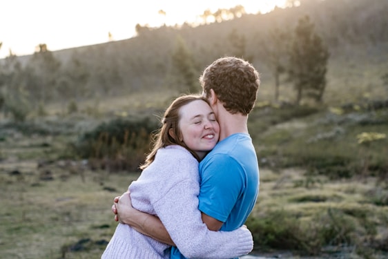 A serene outdoor setting with a couple embracing during sunset.
