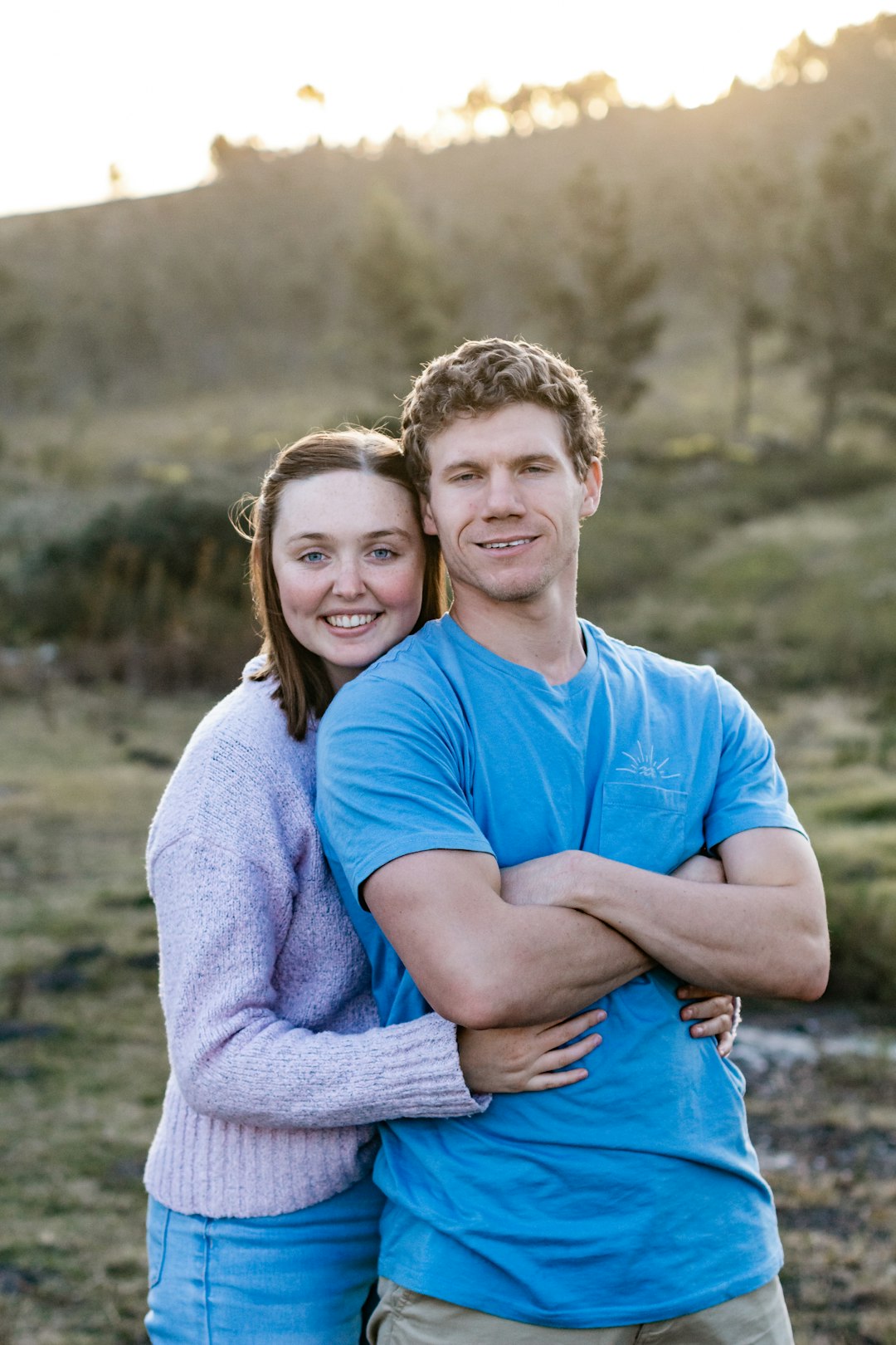 man in blue crew neck t-shirt hugging woman in gray sweater