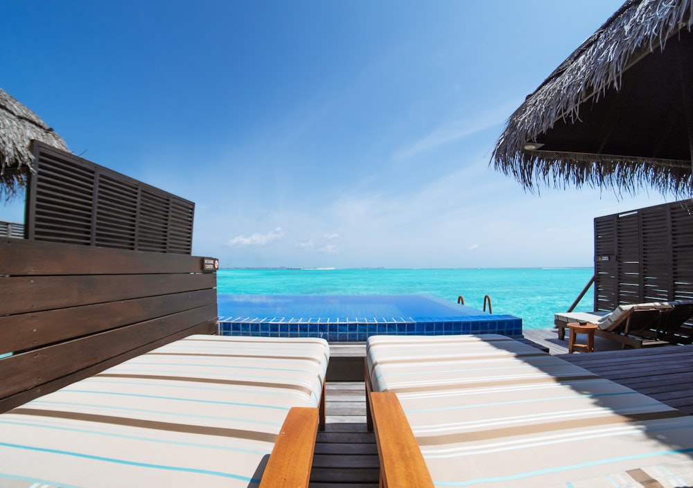 brown wooden beach lounge chair on beach during daytime