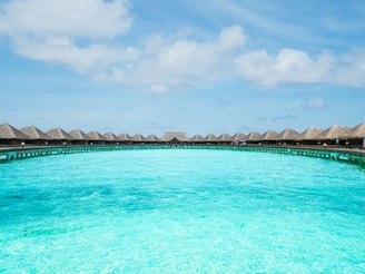 A stunning turquoise lagoon with overwater bungalows under a bright blue sky in the Maldives