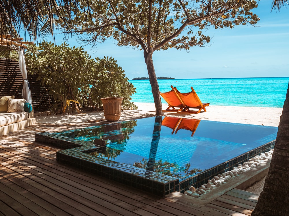 brown wooden lounge chair beside swimming pool during daytime