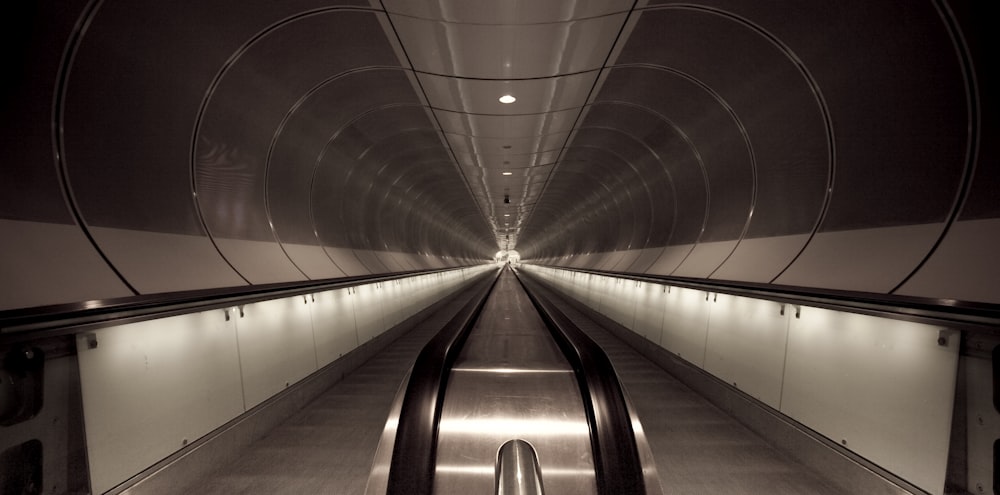 gray and black tunnel with lights turned on during night time