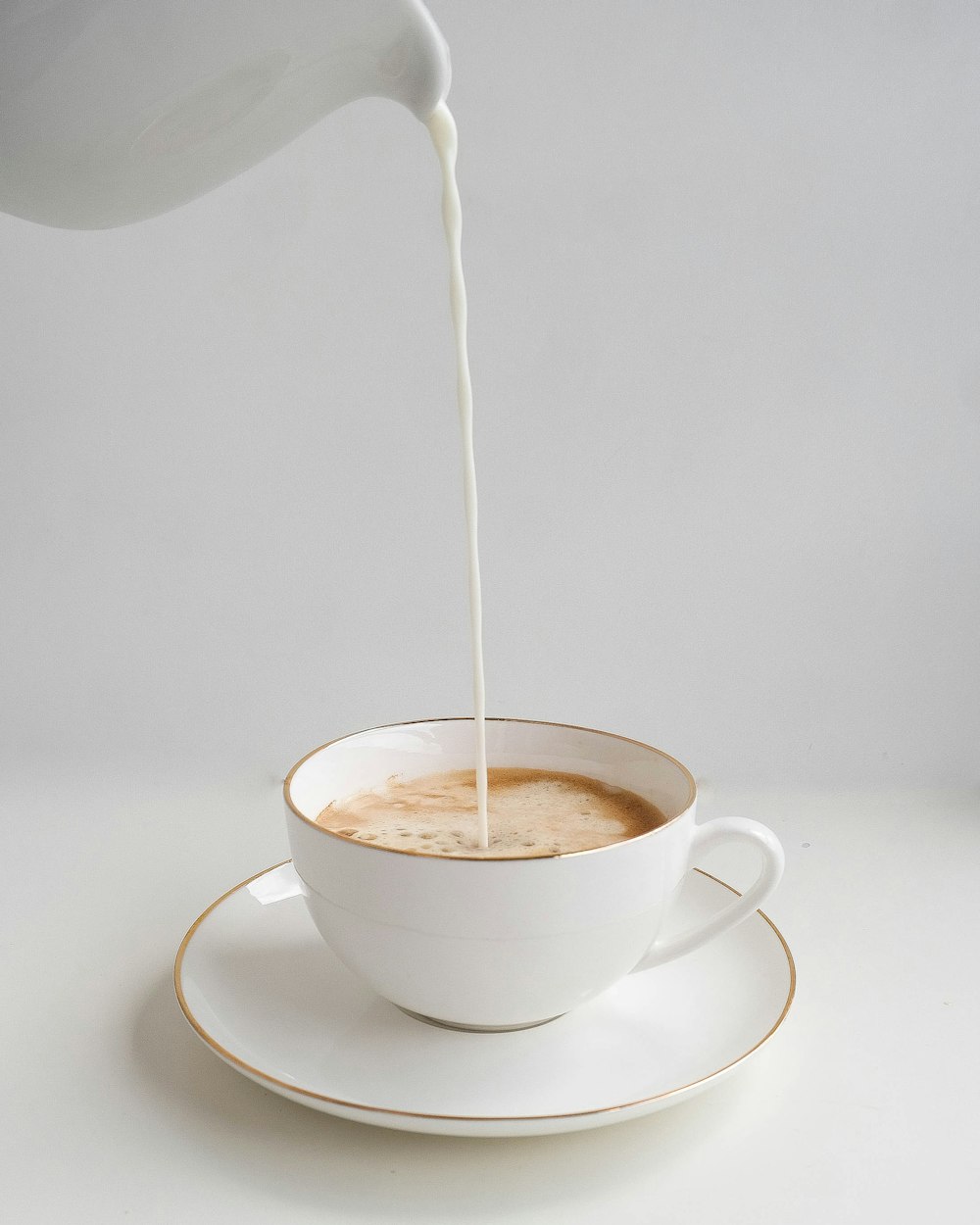 tasse à thé en céramique blanche sur soucoupe en céramique blanche