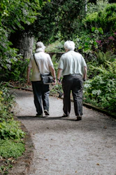 man in white shirt and blue denim jeans walking on pathway