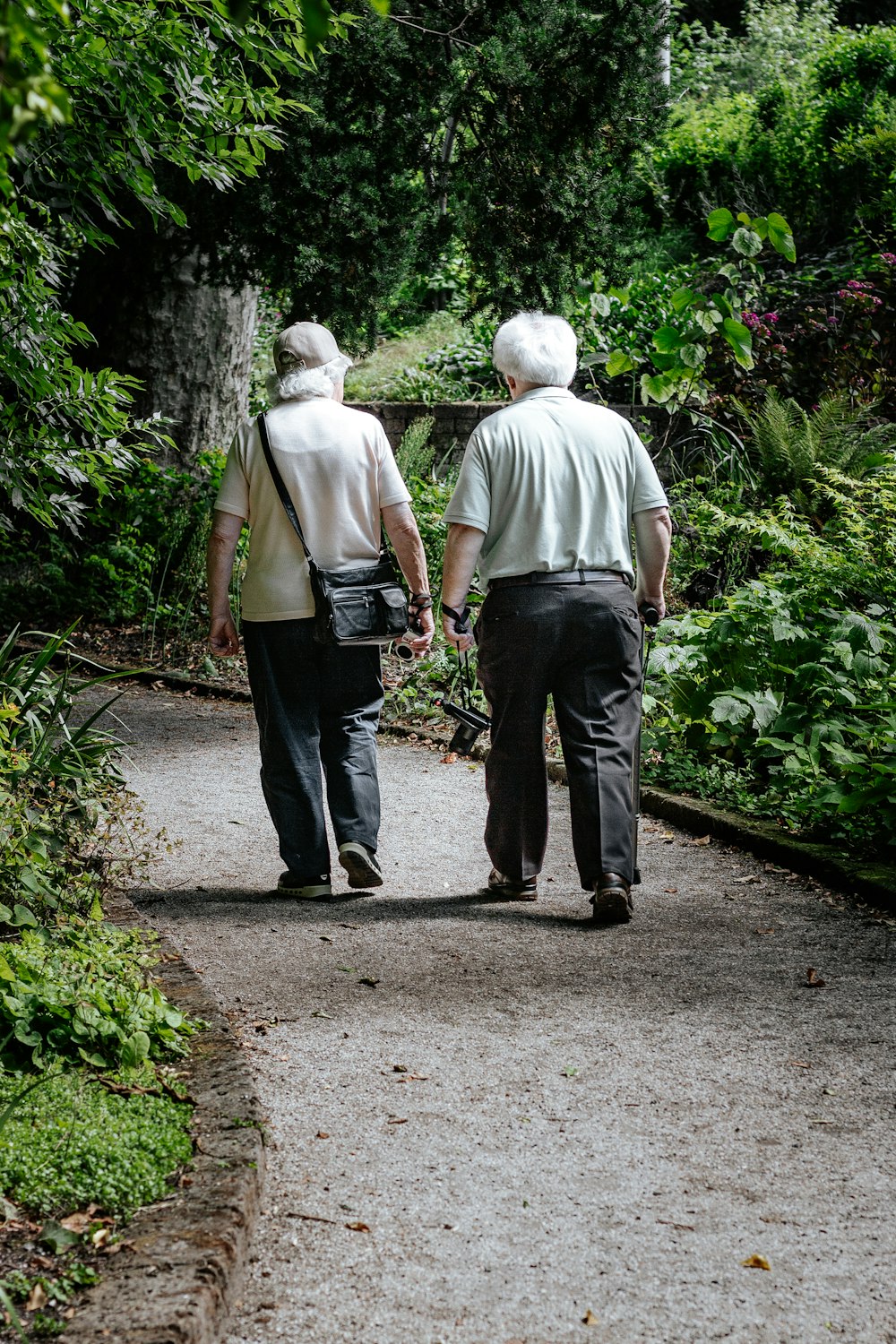 Homme en chemise blanche et jean bleu marchant sur le sentier