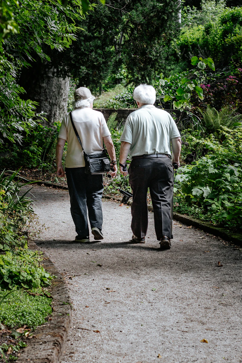 Two retired people walking a garden path