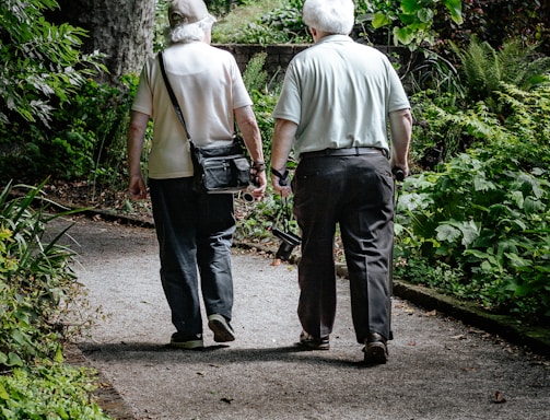 man in white shirt and blue denim jeans walking on pathway