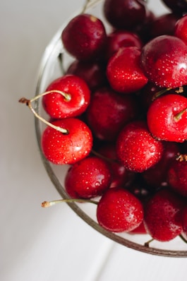 red cherries in clear glass bowl