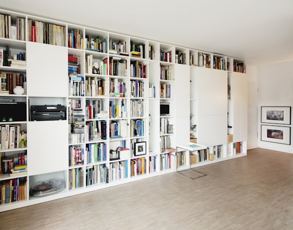 A handyman installing new shelves in a living room.