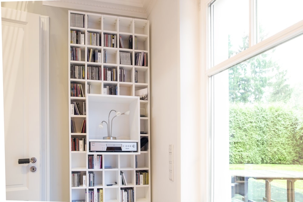 white wooden book shelf near window