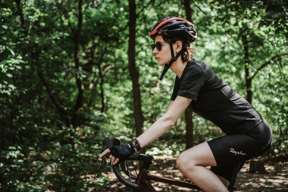 donna in camicia nera che cavalca su bicicletta nera