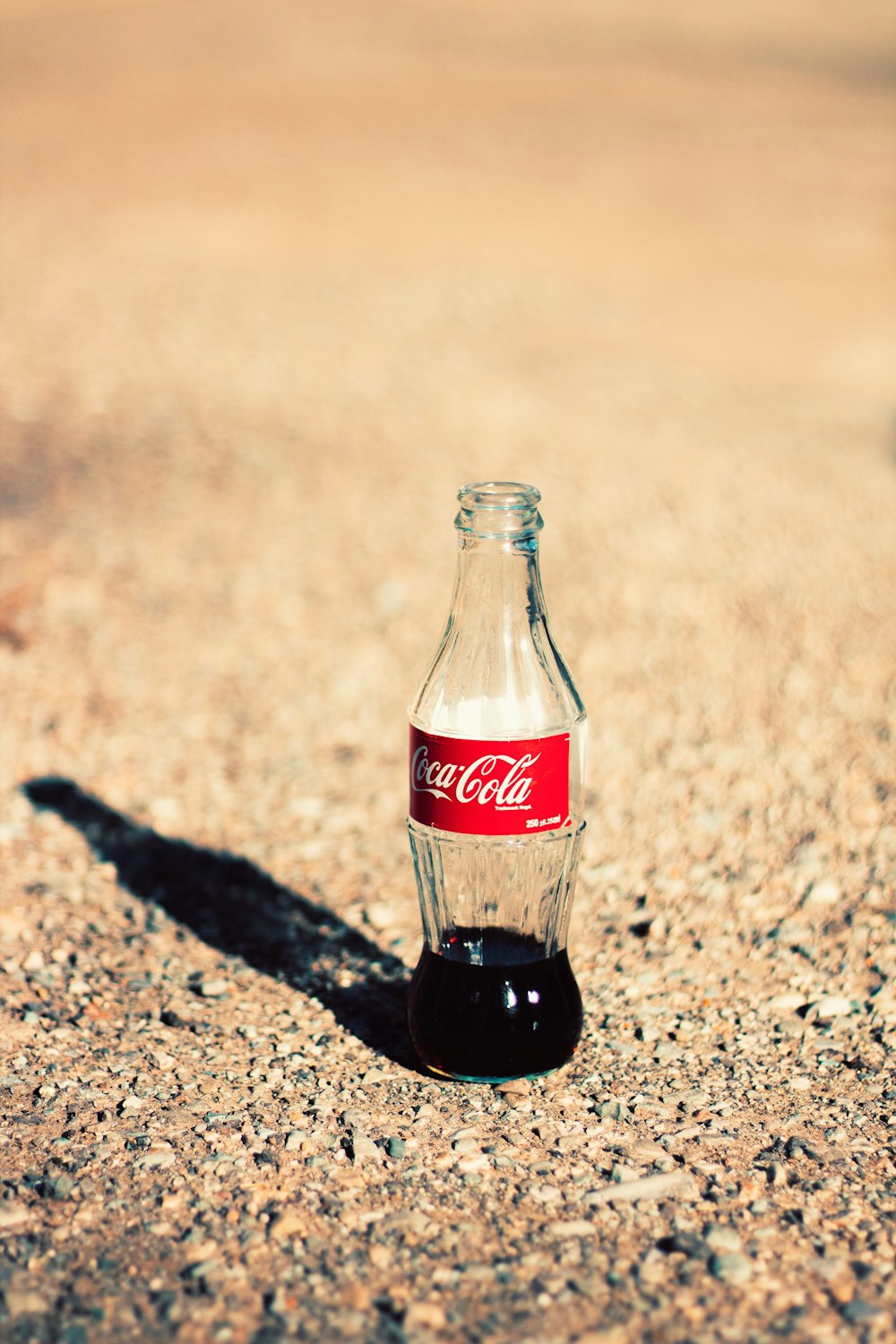 coca cola glass bottle on brown and black marble table