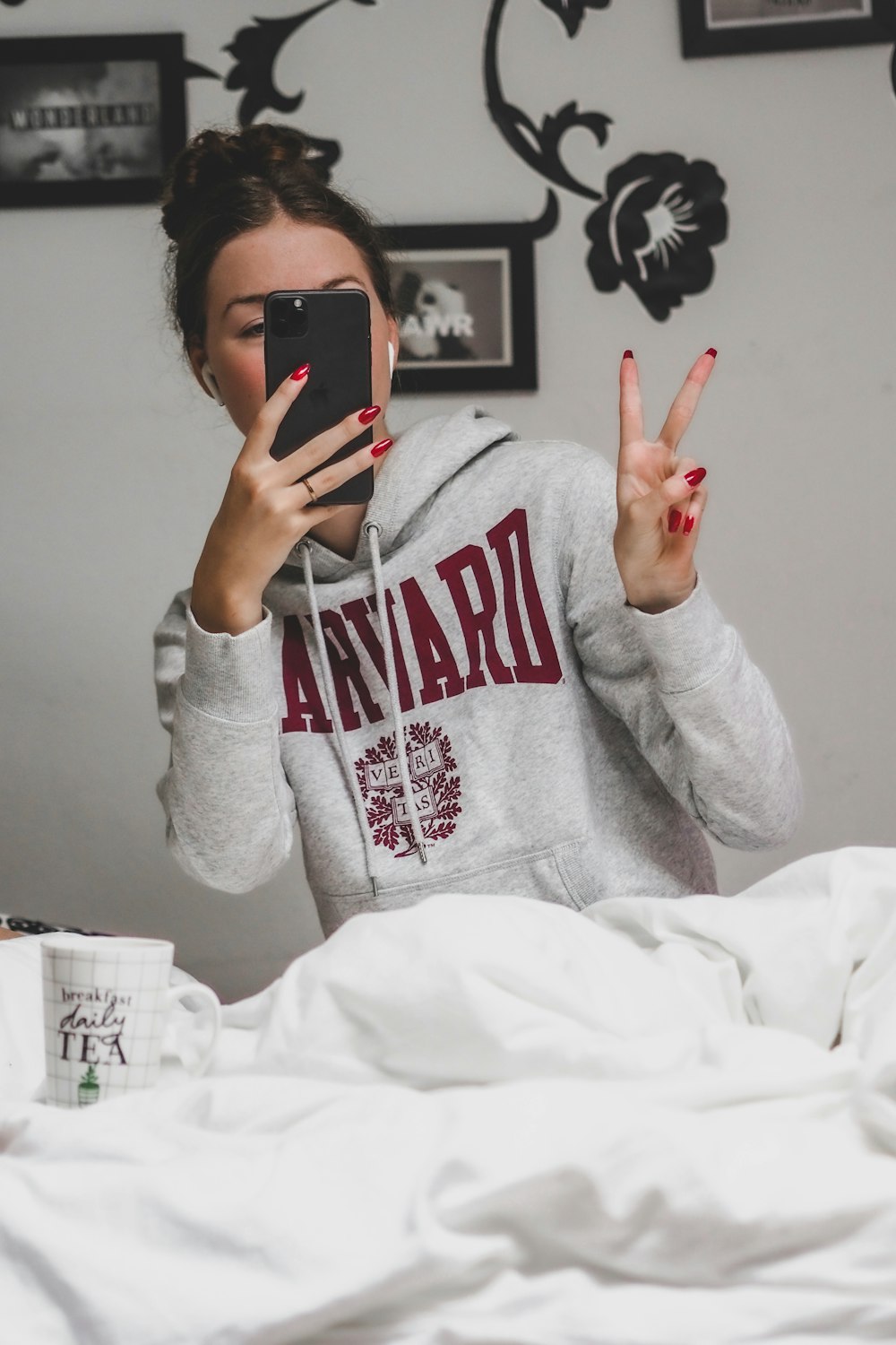 man in gray hoodie holding black smartphone