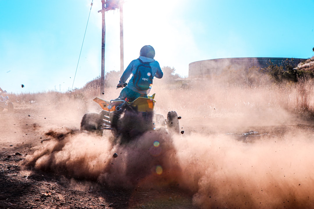 man riding on black and red atv