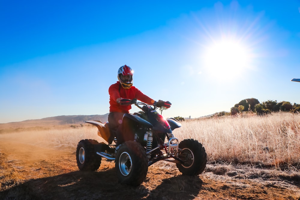 man riding atv on brown field during daytime