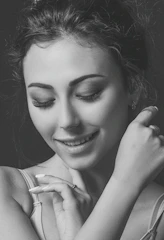 Close-up of a serene woman smiling gently while journaling in a cozy, feminine workspace