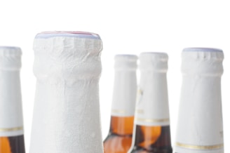 Close-up of hands counting beer cartons to track monthly consumption.