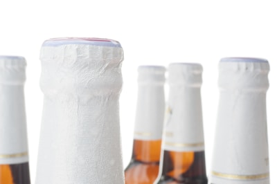 Close-up of glass bottles filled with craft beers lined up beautifully.