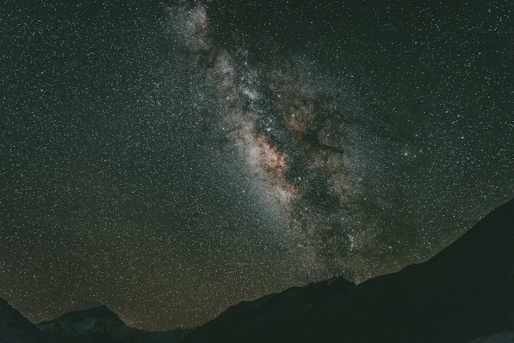 silhouette of mountain under starry night