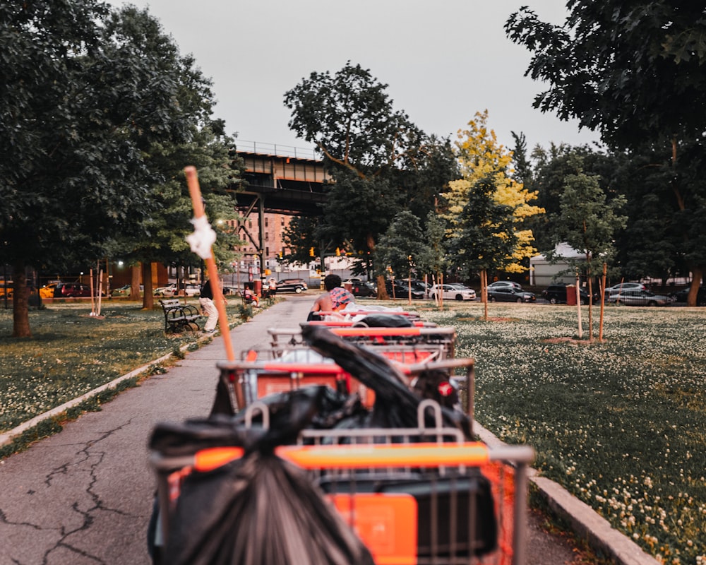 red and black shopping cart on green grass field during daytime