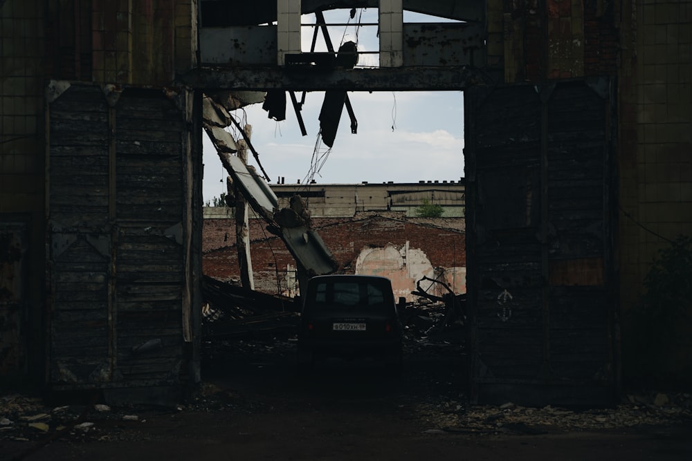 black car parked beside brown wooden house during daytime