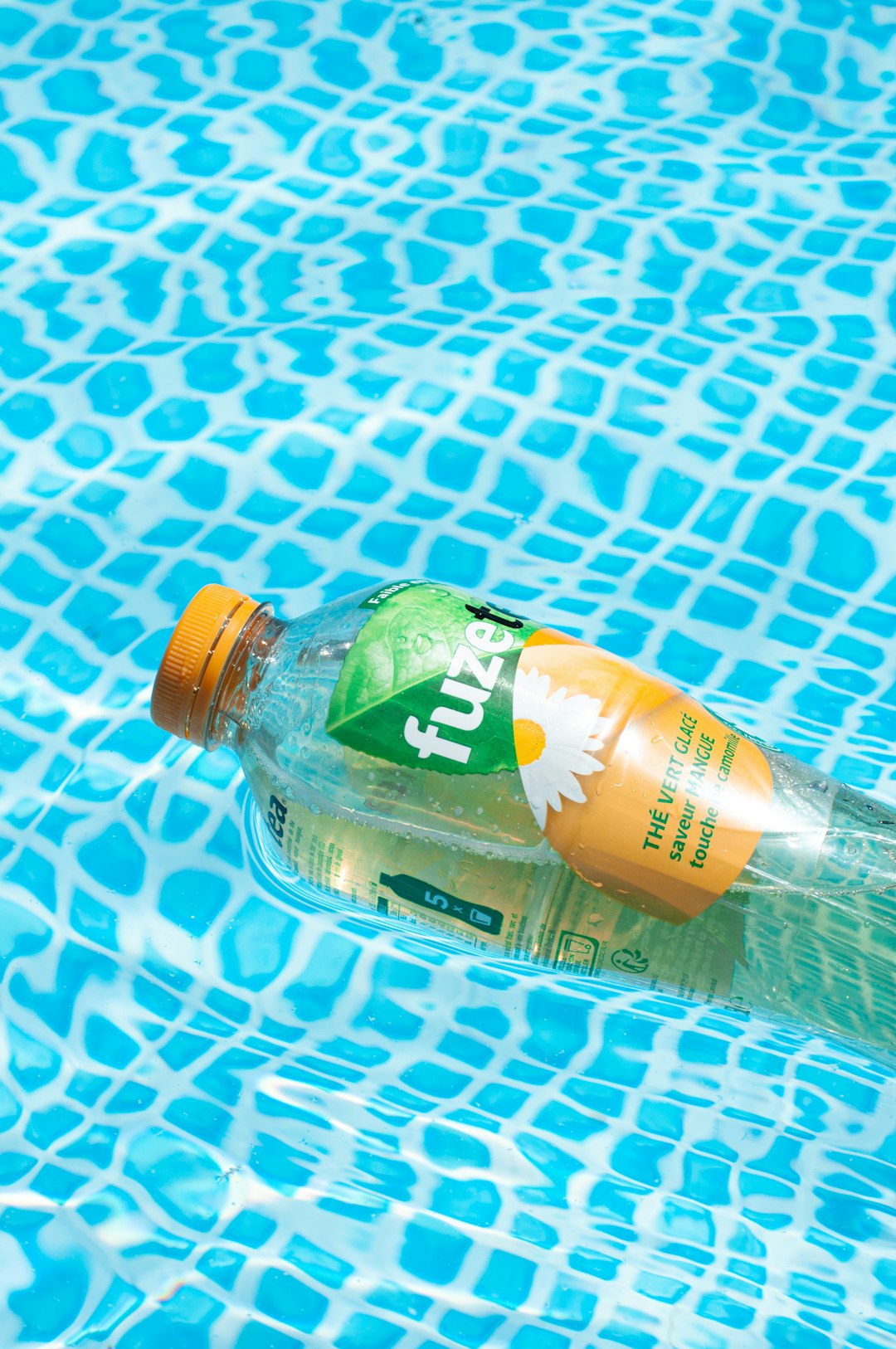 green labeled plastic bottle on blue and white polka dot textile