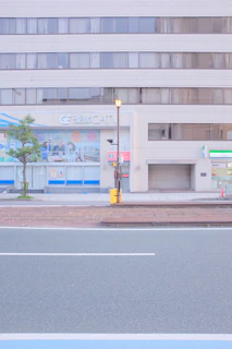 Exterior of a multi-story mixed-use building with storefronts on the ground floor.