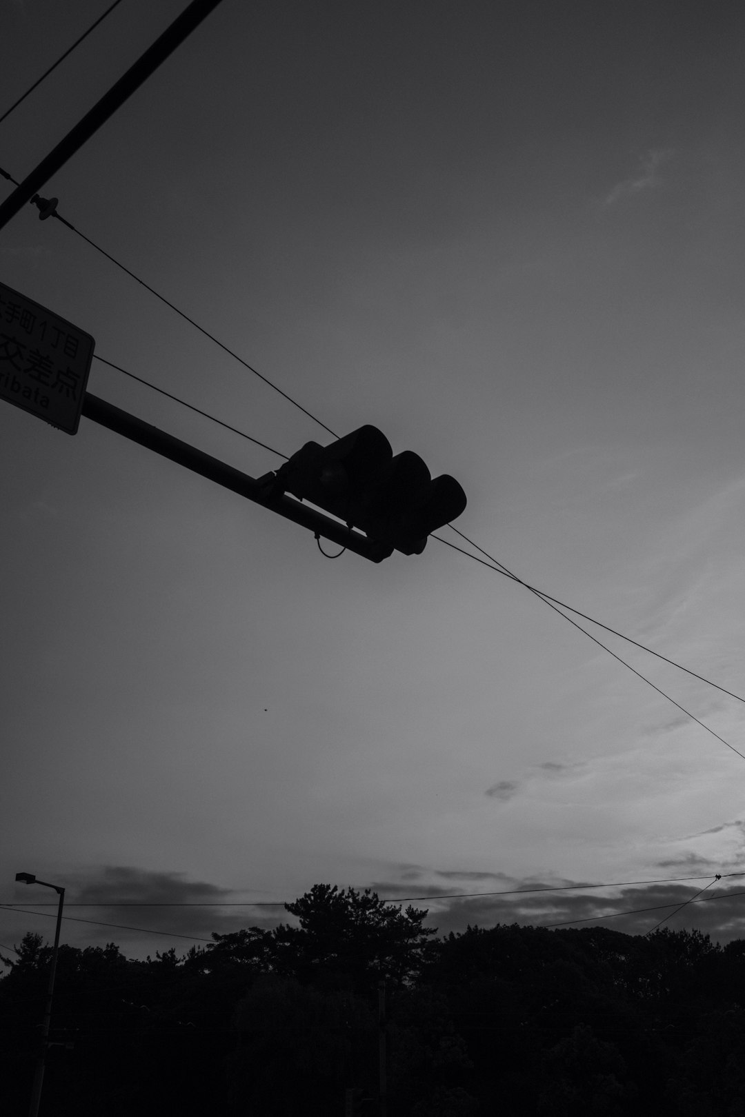 silhouette of traffic light under cloudy sky