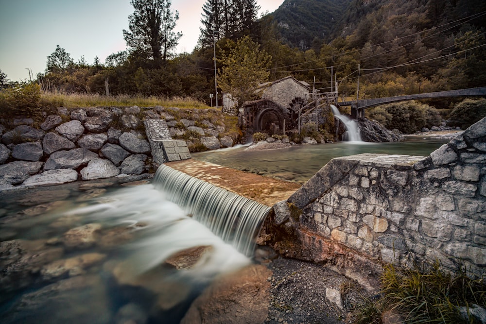 water falls near green trees and brown mountain during daytime