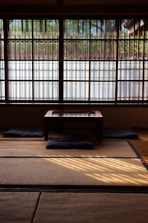 A neatly arranged futon bed on tatami flooring, inviting restful sleep in a traditional setting.