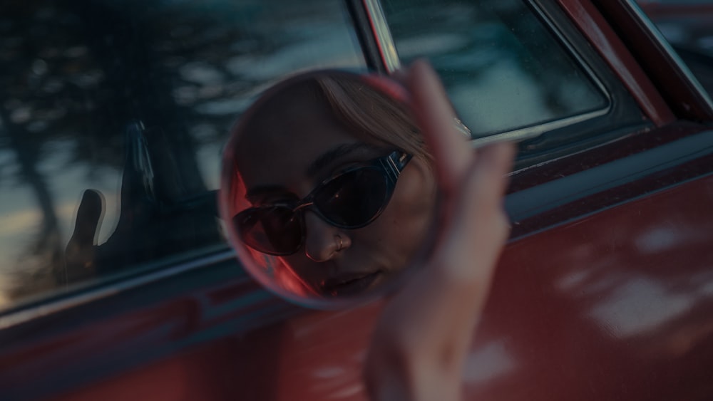 woman in red sunglasses inside car