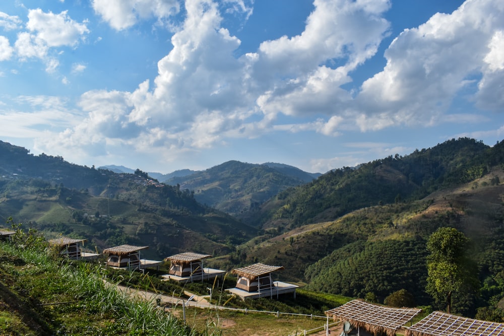 montañas verdes bajo nubes blancas y cielo azul durante el día