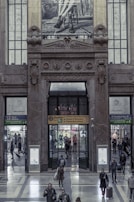 Evening photograph of the Madrid Fashion Day main entrance with sleek black and gold signage.