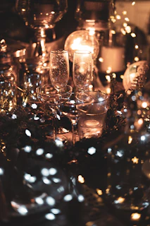 A cozy anniversary celebration with intimate lighting, gold accents, and a couple sharing a heartfelt moment surrounded by loved ones.