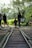 Family with children enjoying a vélorail ride along a historic railway track surrounded by forest and hills.